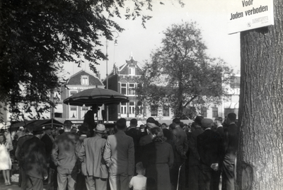 97546 Afbeelding van een groep toehoorders bij, vermoedelijk, een marktkoopman op het Vredenburg te Utrecht met aan een ...
